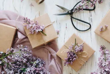 Gifts flatlay with lilac flowers