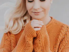 Blonde woman wearing an orange autumn sweater