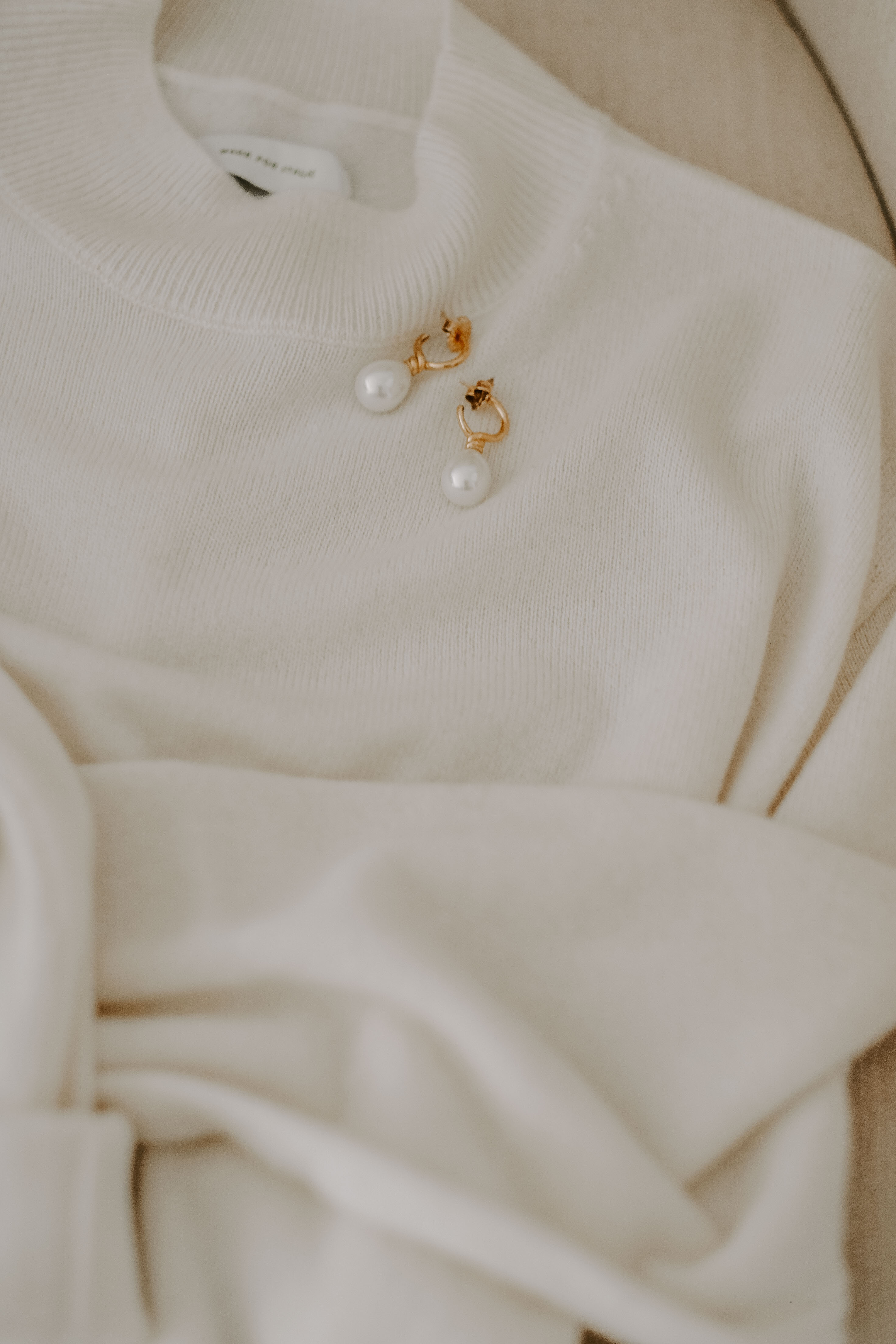 cashmere sweater and pearl earrings