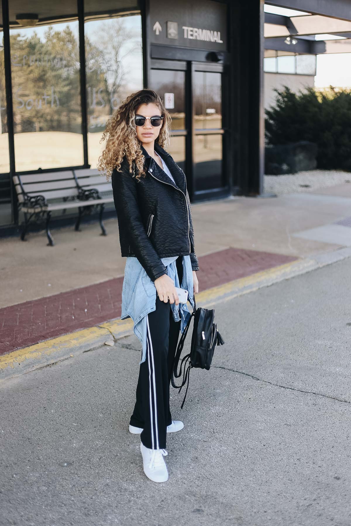 comfy airport outfit with track pants and a motorcycle jacket