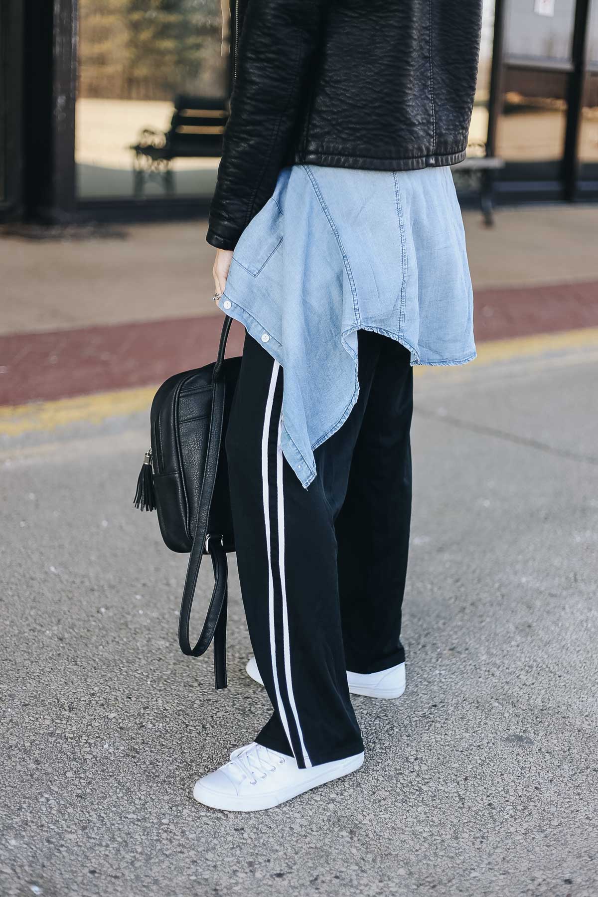 comfy airport outfit with track pants and a motorcycle jacket