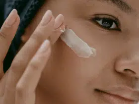 black woman applying eye cream