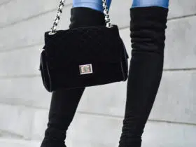 white woman wearing black over the knee boots and skinny jeans